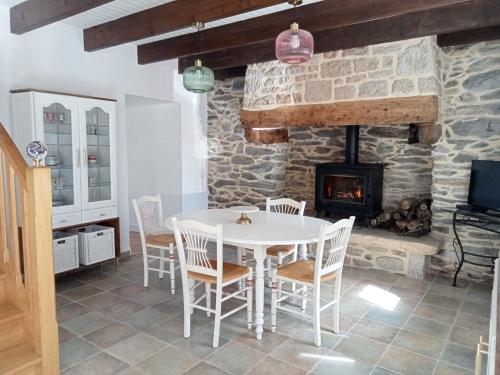 une salle à manger avec une table et une cheminée dans l'établissement Castel Bihan - Maison de caractère entre mer et campagne, à Cast