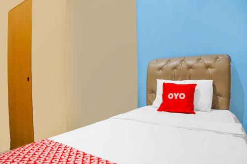 a red pillow sitting on top of a bed at Hotel O Sky Residence Cengkeh in Medan
