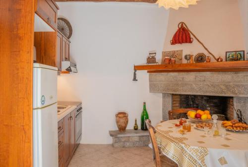 a kitchen with a table and a fireplace at Traditional Cretan House in Zarós