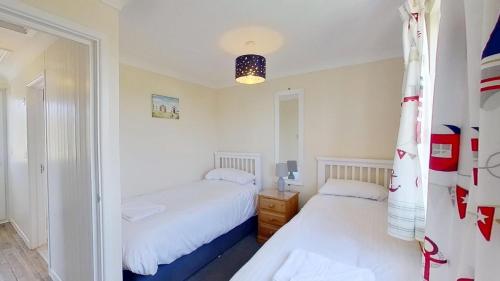 a bedroom with two beds and a mirror at D20 Glendon, Riviere Towans in Hayle