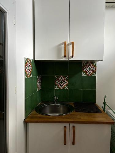 - une cuisine avec un évier et du carrelage vert dans l'établissement Cabanon de Malmousque, à Marseille