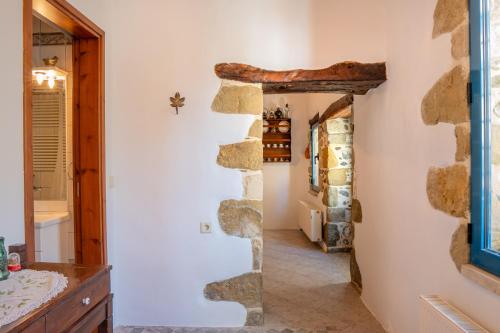 a bathroom with a stone wall and a doorway at Traditional Cretan House in Zarós