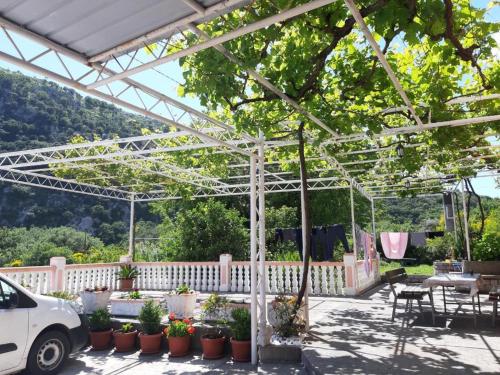 a white pergola with tables and chairs and plants at Vila Marina in Buljarica