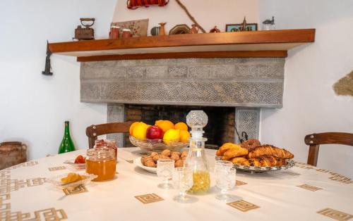 a table with a fireplace with a bowl of fruit at Traditional Cretan House in Zarós