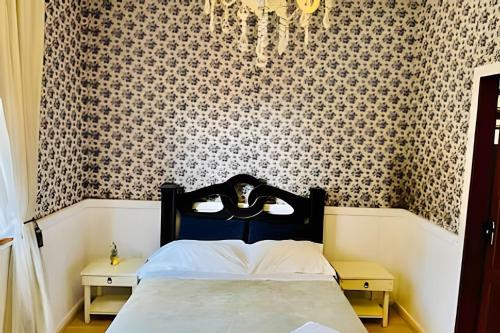 a bedroom with a bed with a black and white wallpaper at Pousada Casa Florinda in Teresópolis