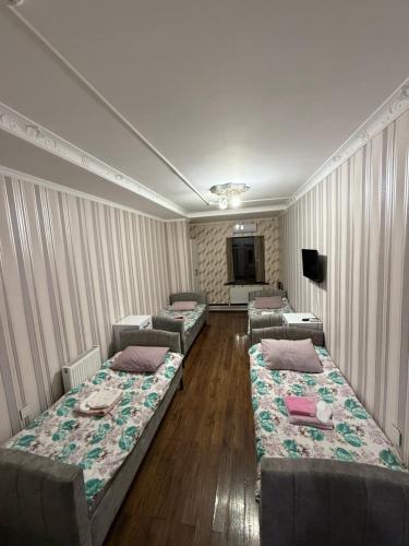 a room with three beds and a television in it at Delfin Hotel & Restaurants & Spa in Ganja