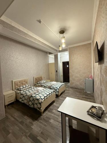 a room with two beds and a table in it at Delfin Hotel & Restaurants & Spa in Ganja