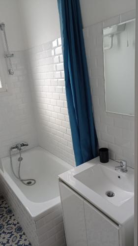 La salle de bains est pourvue d'une baignoire blanche, d'un lavabo et d'une baignoire. dans l'établissement Appartement rénové hypercentre plage à 5 minutes à pied, à Saint-Nazaire