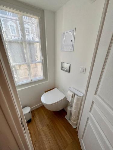 une salle de bain blanche avec toilettes et fenêtre dans l'établissement Les Thermes- Apartment, à Saint-Malo