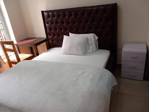 a bedroom with a large bed with a large headboard at Maison De Omashi in Kigali