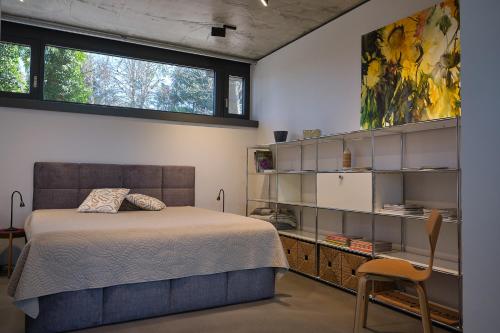 a bedroom with a bed and a desk and window at Architektenhaus Hello in Erbach mit High End Interieur zentral aber ruhig in Erbach im Odenwald