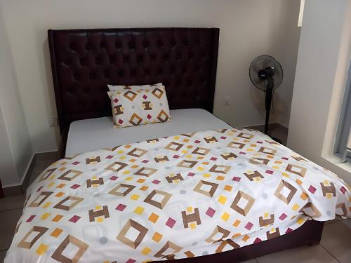 a bed with a bedspread with squares on it at Maison De Omashi in Kigali