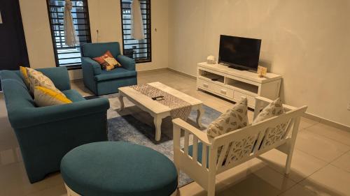 a living room with two chairs and a tv at Malacca City Center Town House by 360HOME in Melaka