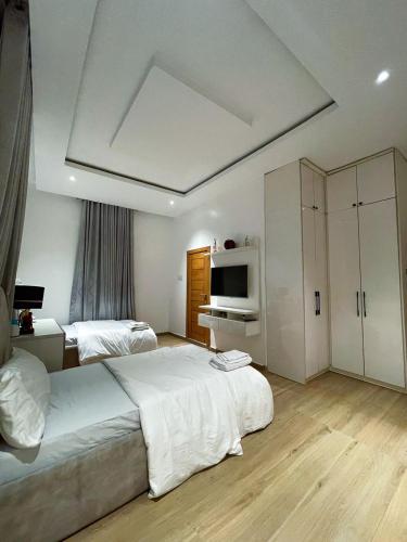 a large bedroom with two beds and a television at 4 Bedroom Duplex in Magodo Phase 2 in Magodo