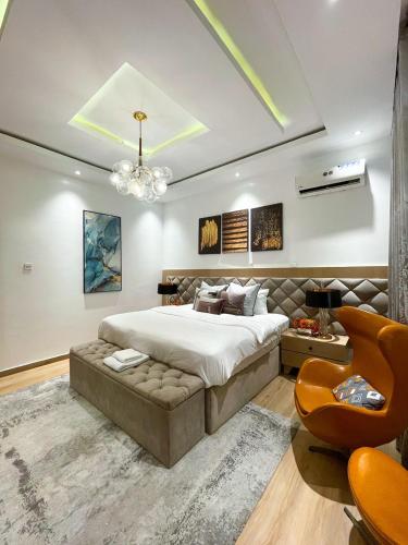 a bedroom with a large bed and a chandelier at 4 Bedroom Duplex in Magodo Phase 2 in Magodo