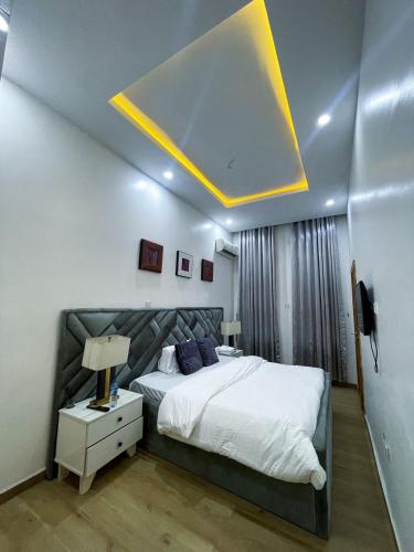 a bedroom with a large bed with a light on the ceiling at 4 Bedroom Duplex in Magodo Phase 2 in Magodo