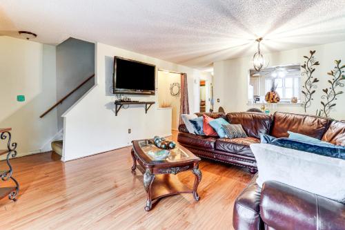 a living room with a leather couch and a table at 3 Mi to Dtwn New Haven Colorful Condo with Yard! in West Haven