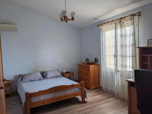une chambre avec un lit, une commode et une fenêtre dans l'établissement Maison d'hôtes avec piscine en juillet et août, à Châteauneuf-du-Pape
