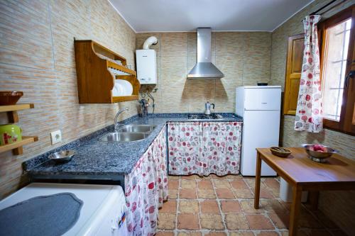 a kitchen with a sink and a refrigerator at Casas Rurales El Portillo in Yeste