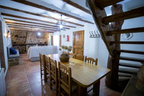 a dining room with a wooden table and chairs at Casas Rurales El Portillo in Yeste