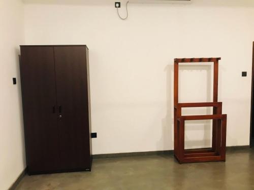 a wooden cabinet and a mirror in a room at Villa Alora in Kamburugamuwa