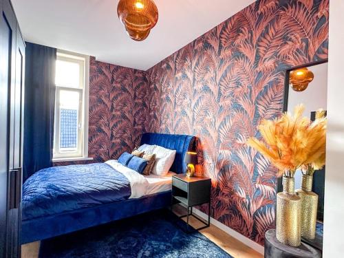 a bedroom with a blue bed and a red wall at Cooth's Royale in Breda