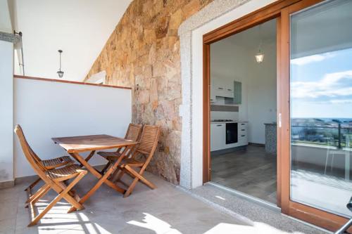 a table and chairs on the balcony of a house at CASE ORCHIDEA - ROSA BLU in La Caletta