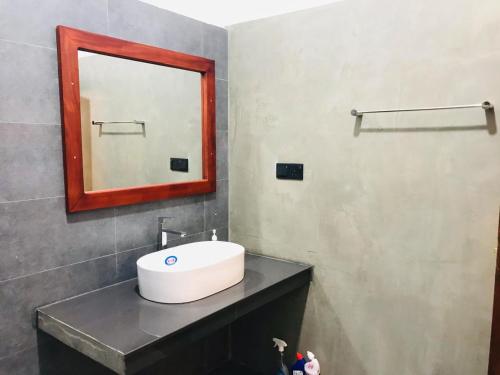 a bathroom with a sink and a mirror on a counter at Villa Alora in Kamburugamuwa