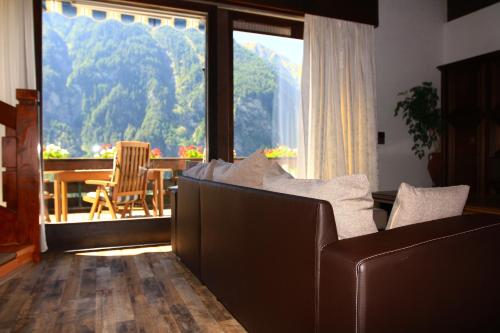 a living room with a couch and a large window at Villa Grossglockner Heiligenblut in Heiligenblut