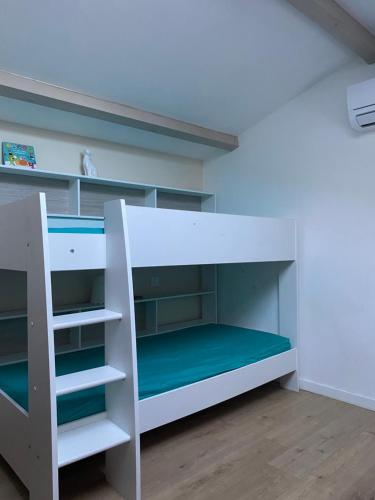 un lit superposé blanc avec un matelas vert dans l'établissement Très beau duplex avec climatisation et piscine, à Grabels