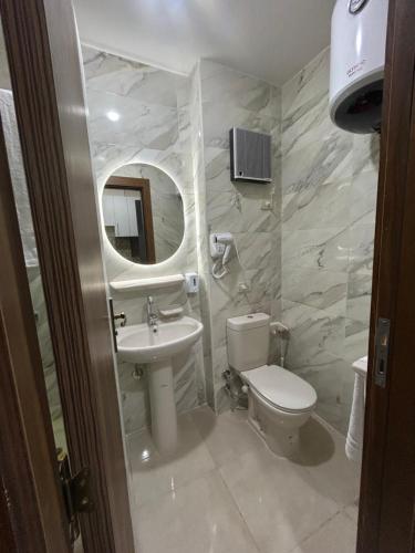 a bathroom with a toilet and a sink and a mirror at Hurghada Holiday Studio with Beach in Hurghada