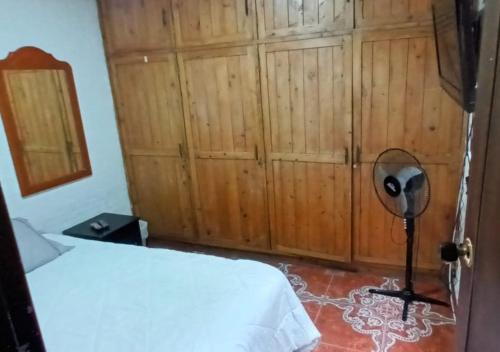 a bedroom with a bed and a wooden wall at Casa amoblada 10 personas 4 habitaciones - Frente al terminal y cable aereo, Expoferias, Bosque Popular y Termales del Otoño in Manizales