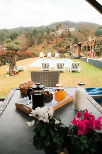 a table with a tray of food and flowers on it at Casa do Rio, 4890 in Basto