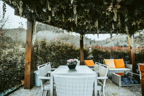 a table and chairs under a pergola with flowers at Casa do Rio, 4890 in Basto