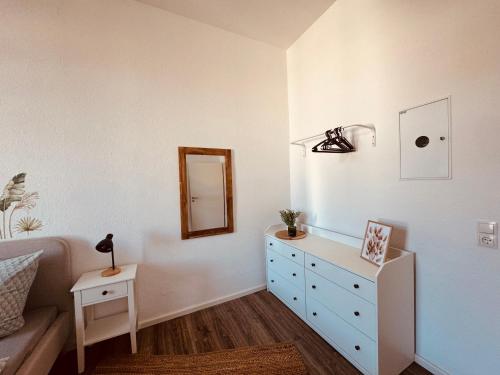 a bedroom with a blue dresser and a mirror at FeWo Nordseebrise in Wilhelmshaven