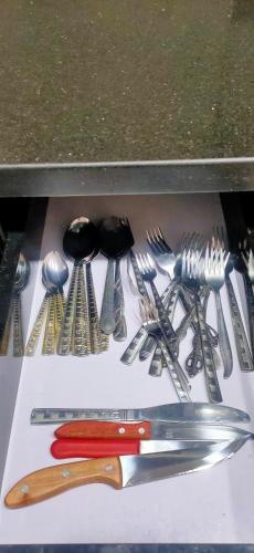 a group of utensils on a table with a red knife at شالية غرفتين Porto Said in Port Said