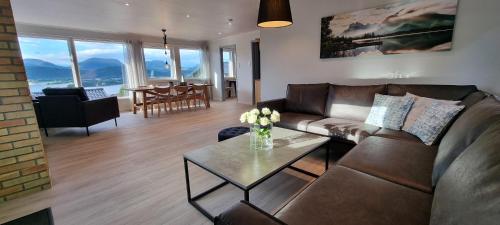 a living room with a couch and a table at Apartment- fjord view, big terrace, close to Moa in Ålesund