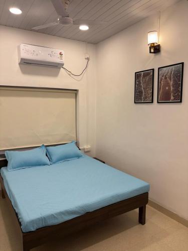 a bedroom with a bed with blue pillows and a heater at Annapurna Beach House in Adi