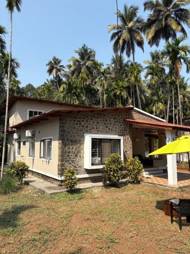 a house with palm trees in front of it at Annapurna Beach House in Adi