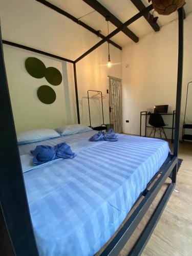 a large bed with blue sheets in a room at Mini Jungle Villa in Manzanillo