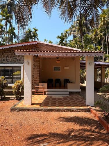a small house with chairs in front of it at Annapurna Beach House in Adi