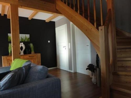 a living room with a blue couch and a staircase at Ferienhaus In Klein Meckelsen Mit Garten in Klein Meckelsen