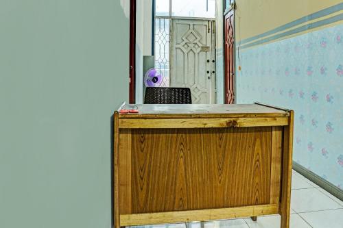 a wooden podium in a room with a mirror at Hotel O Kost Axcel in Banjarmasin