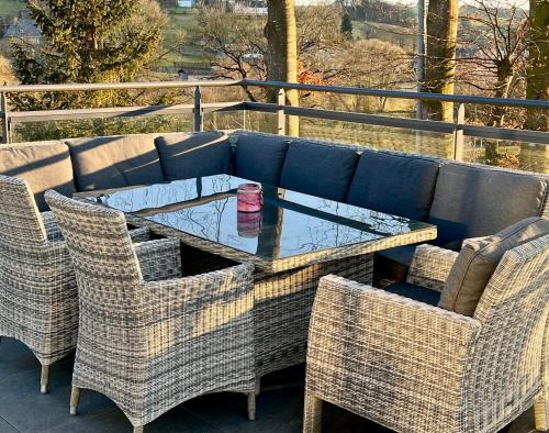 a table with wicker chairs and a drink on it at Haus Wölmen in Heppenbach
