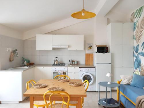 a kitchen and living room with a wooden table and chairs at Apartment Scalea La Petrosa TikiTakiApartments in Scalea