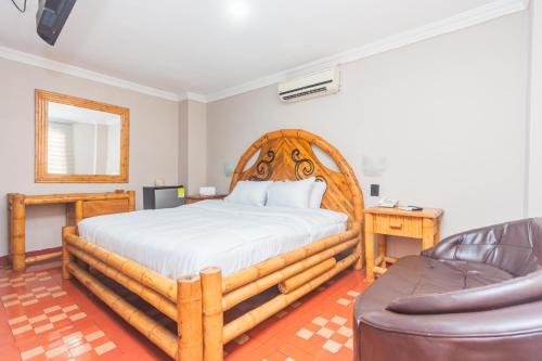 a bedroom with a wooden bed and a couch at Hotel Baluarte Cartagena Boutique in Cartagena de Indias
