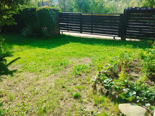 a yard with a fence and a flower garden at Drevenica u Holtana in Oščadnica