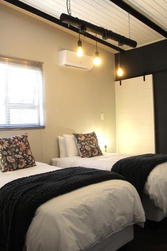 a bedroom with two beds and a window at Lategansrus at Helpmekaar Farm in Wellington