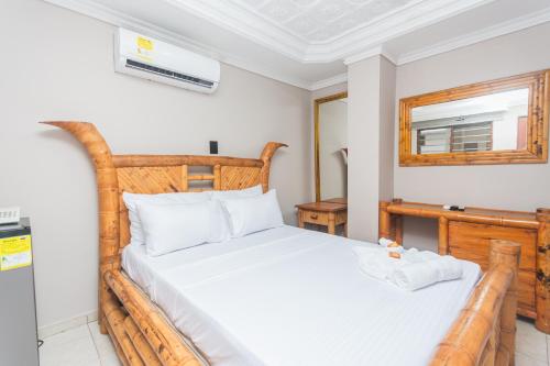 a bedroom with a wooden bed and a mirror at Hotel Baluarte Cartagena Boutique in Cartagena de Indias