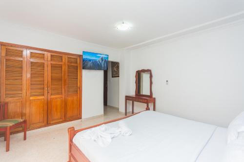 a bedroom with a bed and a wooden cabinet at Hotel Baluarte Cartagena Boutique in Cartagena de Indias